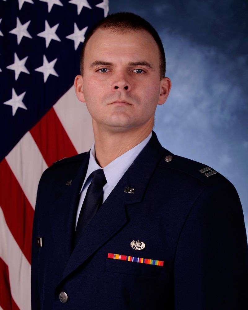 Captain Garrett Ham in Air Force service dress uniform, official portrait with American flag
