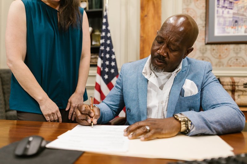 An attorney signing an estate-planning document at a desk, suggesting the careful execution of a comprehensive Arkansas estate plan.